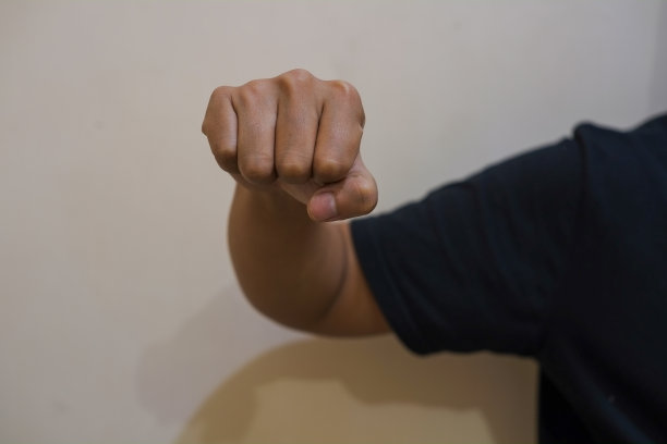 那只手攥得紧紧的。孤立的奶油背景。侵略姿态、冲突和威胁概念图片下载