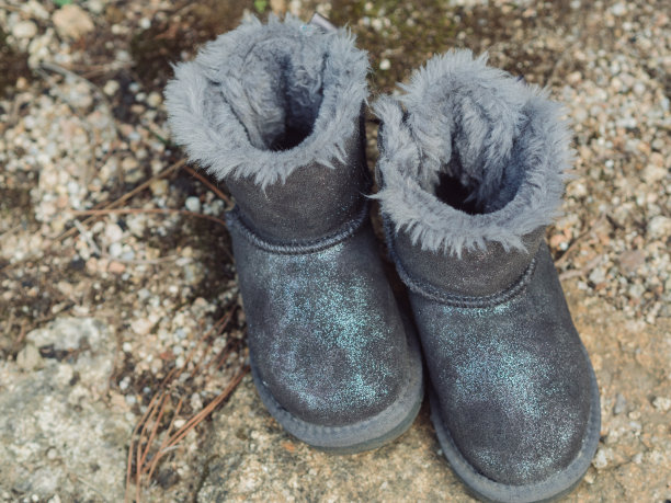 撒丁岛岩石地面上的儿童灰色羊皮靴图片下载