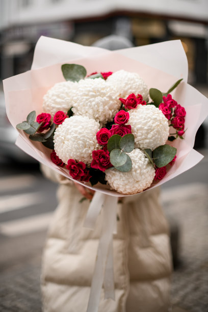 一大束白色的菊花，包着小玫瑰，背后藏着一个女人图片下载