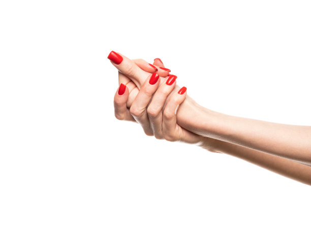 一个女孩用一把护手霜在手上涂上红色的指甲。照片隔离在白色背景上。图片下载