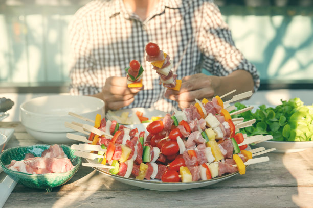 一个男人在户外为朋友准备烧烤。图片下载