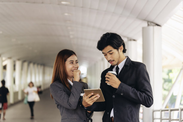 年轻的亚洲商人微笑着在上班前喝杯咖啡放松一下。情侣们在现代都市里一起喝咖啡。商务人士在办公室端着一杯咖啡图片下载