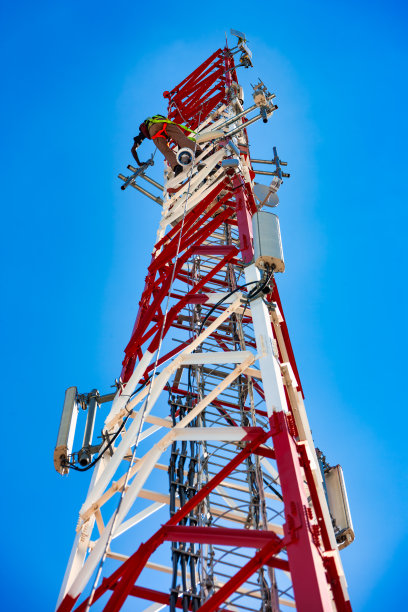 蜂窝塔天线上的技术员，晴朗的天空背景图片下载