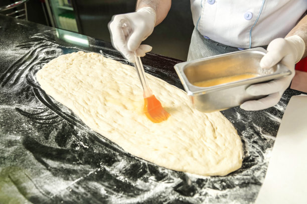 戴白手套的人在做披萨图片下载