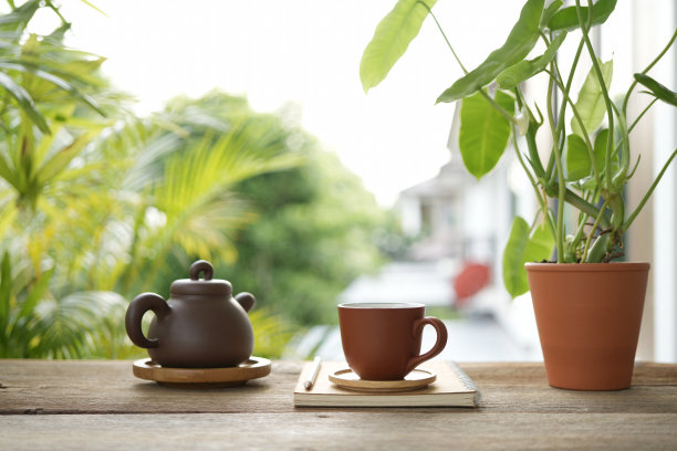 阳台上的茶杯和陶器茶壶和笔记本侧视图图片下载