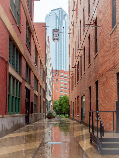 红砖建筑通往摩天大楼的小巷。这张照片摄于德克萨斯州达拉斯市中心的一个下雨天图片下载