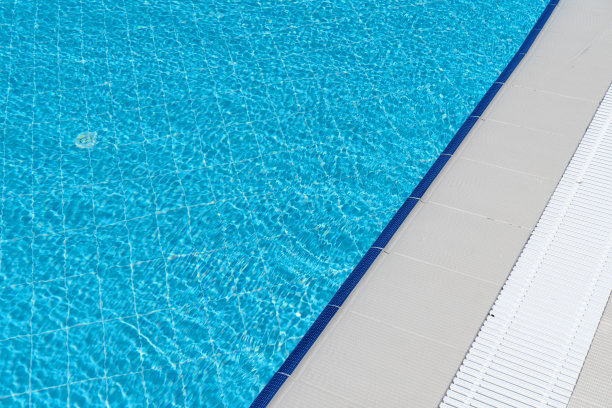 游泳池里的水反射出波纹。泳池水面图案的背景照片。波纹和清澈的绿松石水面图片下载