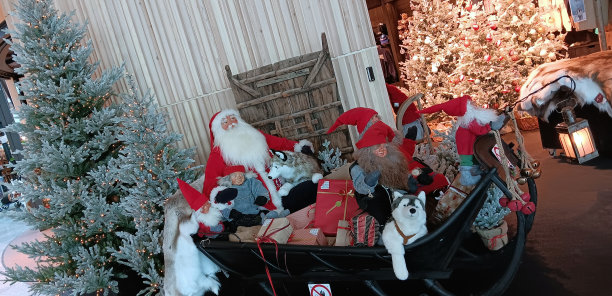 在赫尔辛基的一家机场商店里，一群快乐的玩具圣诞老人，他们留着传统的白胡子，穿着象征圣诞节的红色服装图片下载