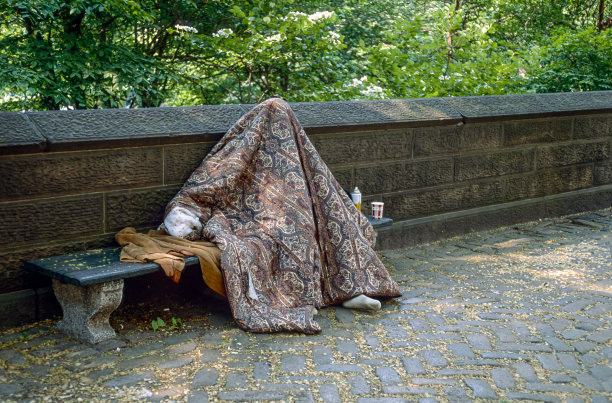 一张历史彩色照片的扫描幻灯片，一个无家可归的人坐在曼哈顿中央公园的长椅上，完全被毯子覆盖着图片下载