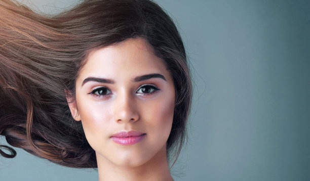 女人，工作室或肖像与运动的头发护理和化妆，美学与面部光泽。女性人士，美容改造或化妆品以蓝色背景和模型，高光与波浪图片下载