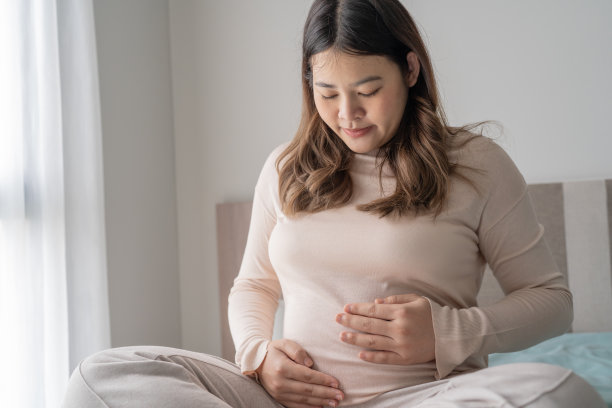 怀孕的亚洲妇女双手放在肚子上抚摸她的孩子，关心她的健康美丽快乐怀孕womanÂ温柔的心情怀孕照片图片下载