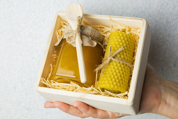 礼品中含有维生素和有机产品。蜂蜜在一个罐子里，用一根棍子和蜡烛。盒子里的礼物。图片下载