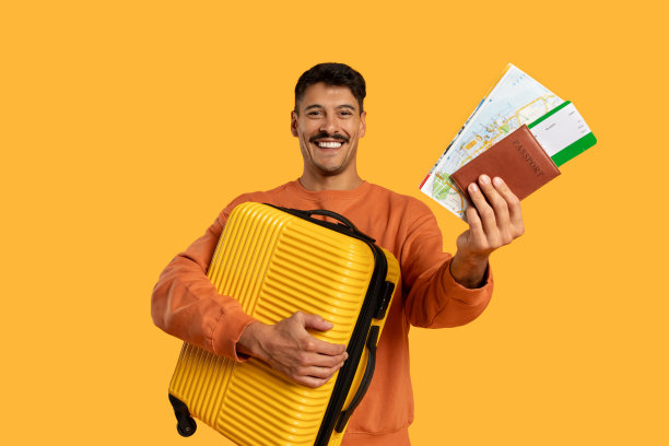 拿着黄色行李箱和黄色背景护照的男子图片下载