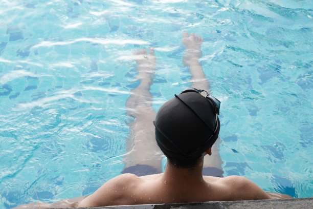 亚洲男人练习游泳和马球，伸展和休息的水上运动。图片下载