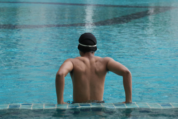 亚洲男人练习游泳和马球，伸展和休息的水上运动。图片下载