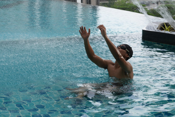 亚洲男人练习游泳和马球，伸展和休息的水上运动。图片下载