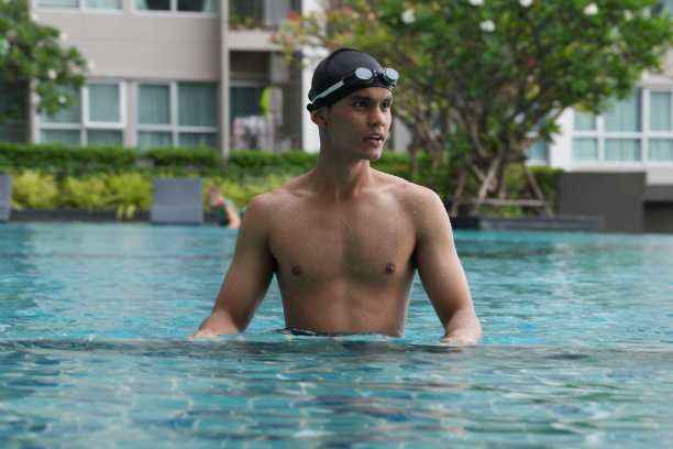 亚洲男人练习游泳和马球，伸展和休息的水上运动。图片下载