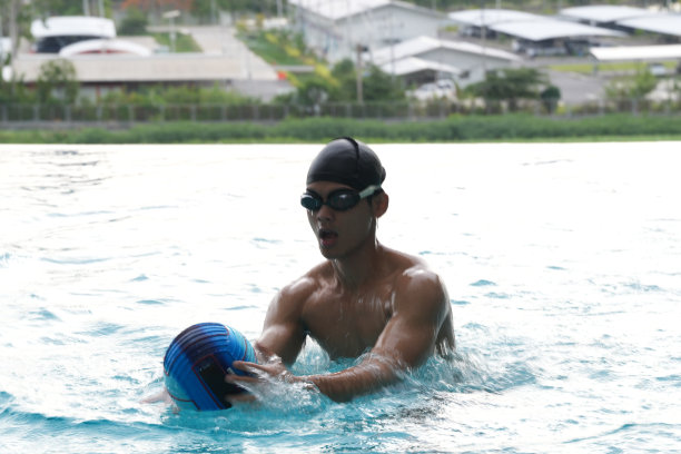 亚洲男人练习游泳和马球，伸展和休息的水上运动。图片下载
