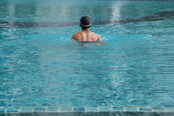 亚洲男人练习游泳和马球，伸展和休息的水上运动。图片下载