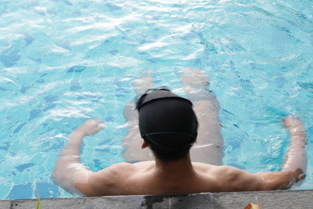 亚洲男人练习游泳和马球，伸展和休息的水上运动。图片下载