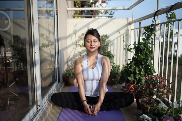 一个中年妇女在阳台上做瑜伽的照片图片下载