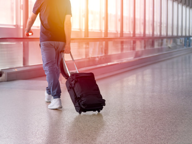 无法辨认的男子在机场候机楼提着行李箱行走的模糊照片图片下载