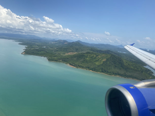 从飞机上鸟瞰热带岛屿，普吉岛，泰国。照片中的飞机机翼图片下载