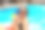 漂亮的年轻女士在室外游泳池休息时拿着玩具水枪摆姿势。副本的空间。夏日、度假和生活方式的概念图片下载