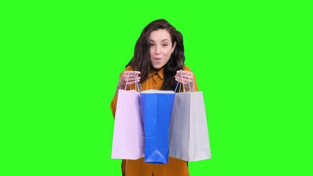 在色度键上购物后惊讶地看着包装的女人图片下载