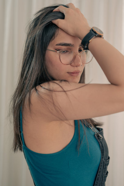 戴眼镜和手表的时尚年轻女人图片下载