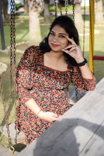 一名怀孕的印度妇女在户外拍摄怀孕照片，手放在肚子上，印度孕妇在社会公园穿着孕妇装把手放在肚子上，怀孕的孕妇在户外拍摄图片下载