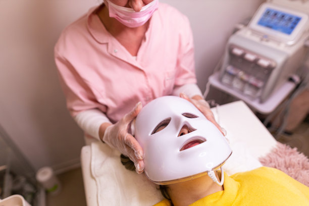 在水疗中心享受面部护理的女性。可爱的女性在健康水疗沙龙做面部手术时放松。温泉电热面膜。库存图片图片下载