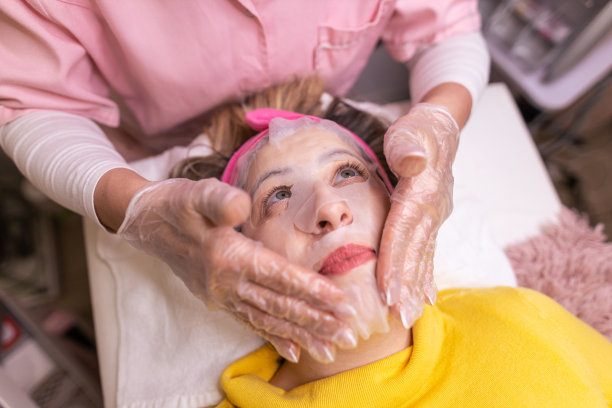 在水疗中心享受面部护理的女性。在水疗中心接受面膜治疗的女性。给自己放松的时间。库存图片图片下载