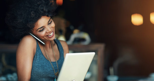 用平板电脑、打电话，然后在咖啡店与一名女子预约，处理一份在线外卖订单。与一位在餐馆工作的黑人女咖啡馆老板的联系、技术和交流图片下载