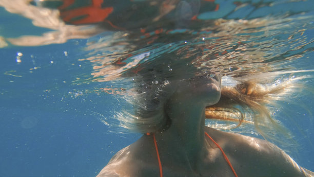 年轻女子游泳的水下照片图片下载