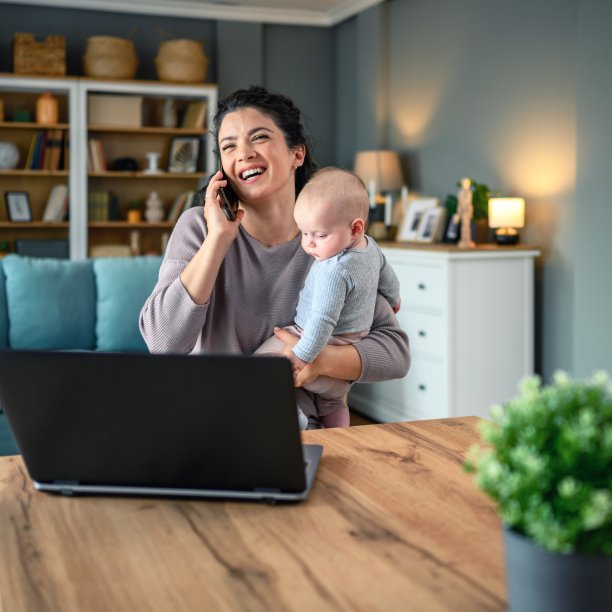 妈妈抱着孩子在家里讲电话图片下载