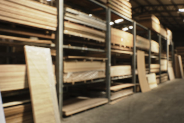 工业存储工厂内部主体照片的模糊和散焦背景。配货仓库中一排排的木板，采光自然。没有人。图片下载