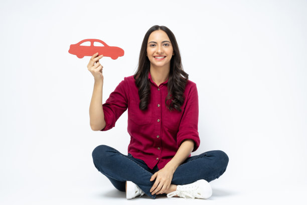 开朗可爱的女人穿着时髦的衣服，坐在地板空空间孤立的白色背景股票照片图片下载