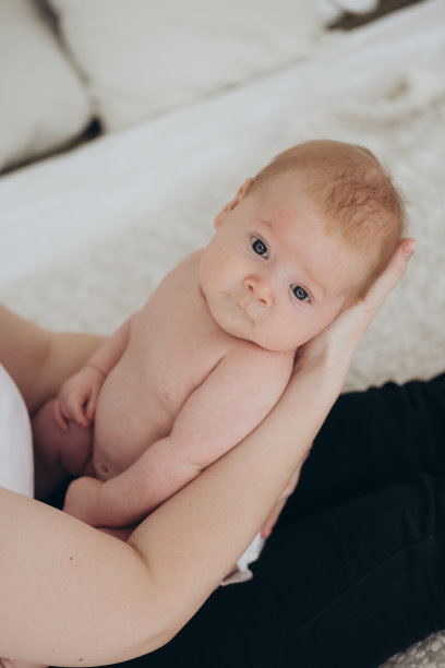 一个婴儿在母亲怀里的特写照片，一个刚出生的男婴图片下载