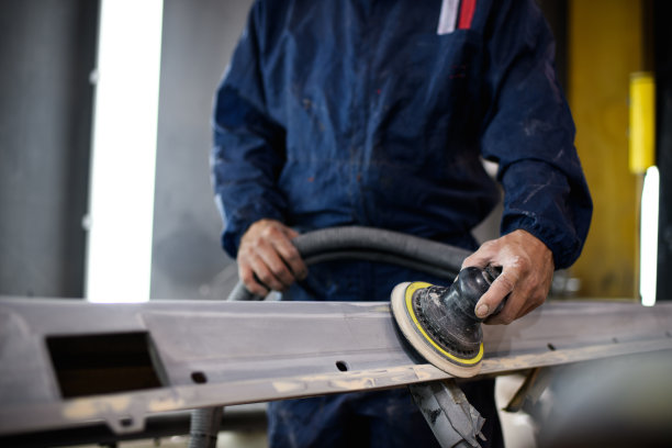 服务人员穿着西装在车库里打磨汽车零件的无脸照片图片下载