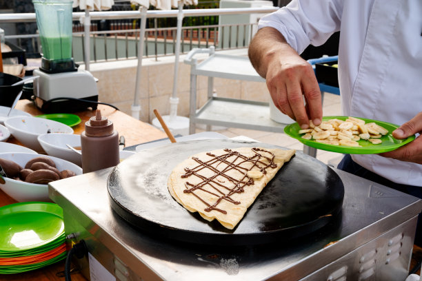 厨师把香蕉放在巧克力上crêpe图片下载