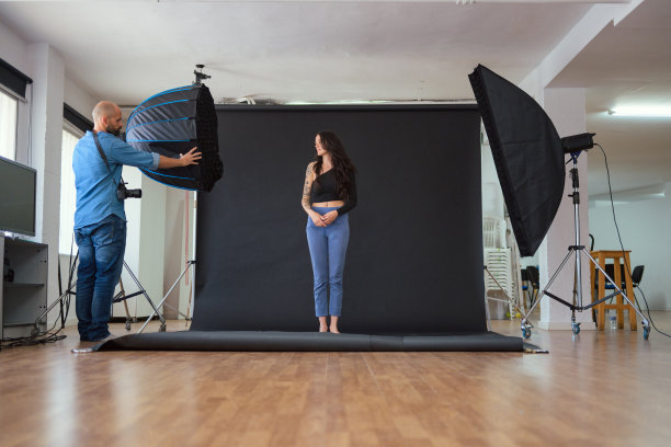 摄影师在摄影棚里用柔光箱拍摄模特图片下载