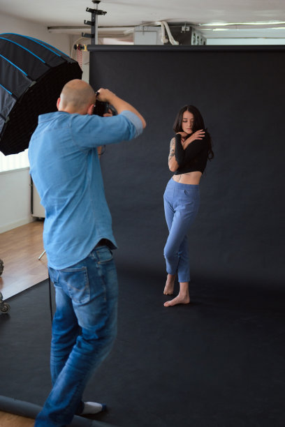 摄影师在摄影棚里用柔光箱拍摄模特图片下载