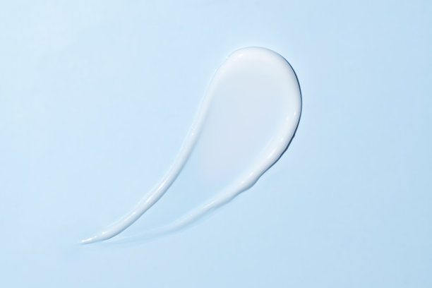 化妆品涂抹白色保湿乳液隔离上蓝色，挤出和涂抹部分护肤霜产品的测试。图片下载