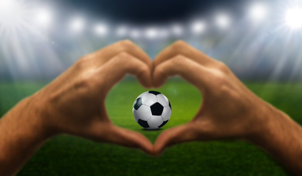 心的手与足球在体育场图片下载