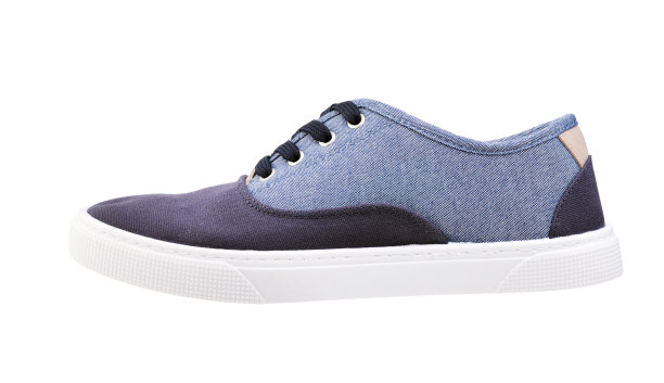 一个男人的白色鞋底的蓝色纺织品运动鞋的孤立照片。图片下载