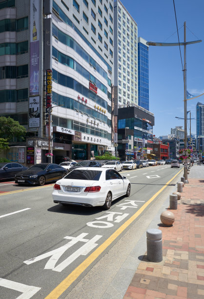在一个阳光明媚的夏日，汽车行驶在韩国釜山繁忙的街道上图片下载