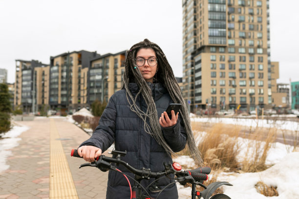 照片上，一名年轻女子在骑自行车时停下来休息图片下载