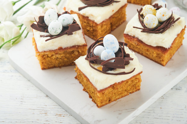 复活节胡萝卜蛋糕棒装饰巧克力窝和巧克力糖蛋开花樱桃或苹果花在乡村轻木制背景。复活节的节日大餐。传统的复活节食物。图片下载