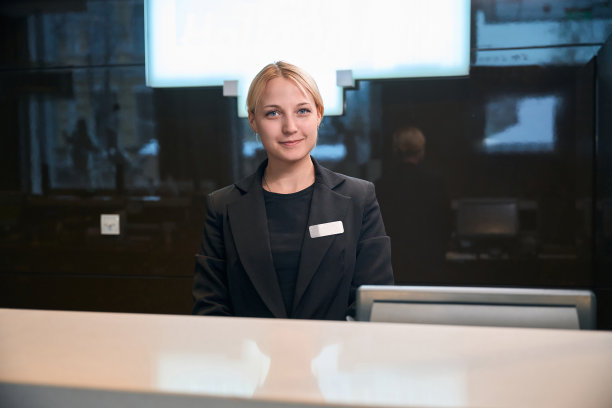 酒店大堂前台接待员看着摄像头的照片图片下载
